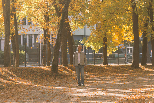 Man on city street, enjoy walking on nice weather autumn day