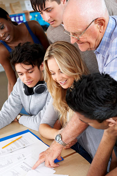 istock Teacher assisting teenage students 174496733