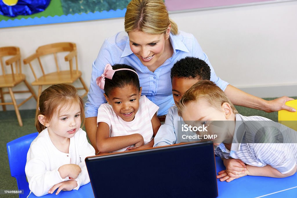 Hermoso profesores, estudiantes usando computadora portátil en jardines - Foto de stock de Maestro libre de derechos