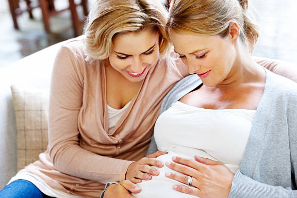 Pregnant woman whit friend in cozy living room.