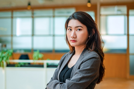 portrait of serious young businesswoman crossed arms looking at camera