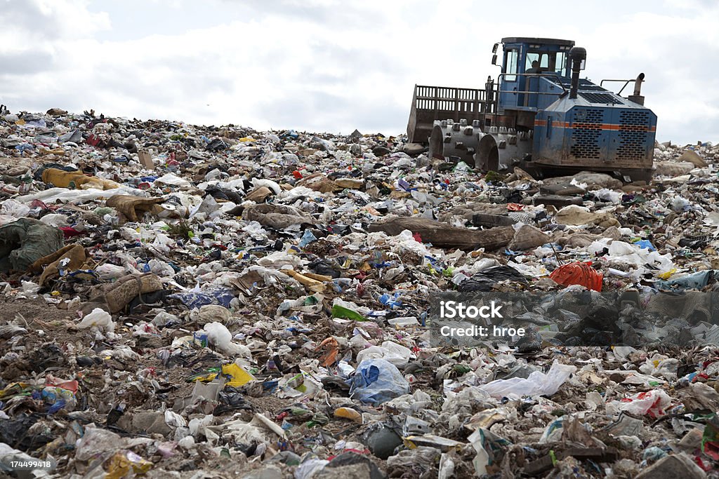 Truck working landfill Garbage piles up in landfill site each day while truck covers it with sand for sanitary purpose Garbage Stock Photo