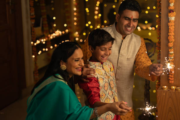 istock Parents with son burning sparklers at home during Diwali 1745004747