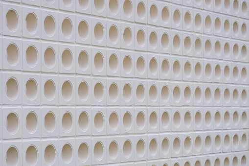 White ventilation block wall background with circle pattern in modern loft style, perspective side view