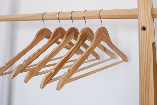 Wooden coat hanger / clothes hanger on a white background. Potential copy space above and inside hanger.