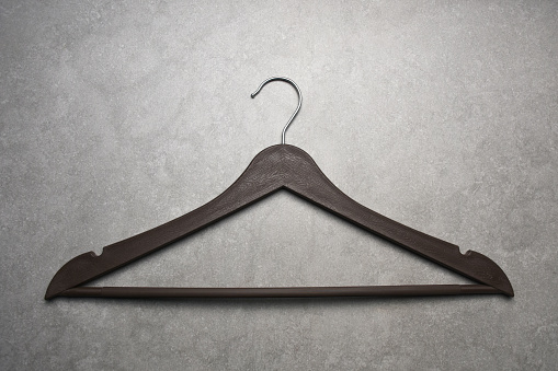 Wooden coathanger on gray color stone background