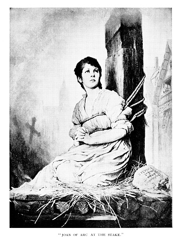 Joan of L’Arc tied at the stake on the charge of witchcraft in 1431 during the Hundred Years’ War. French, English, and European History. Painting by artist Gabriel Max. Engraving published in 1892. Original edition is from my own archives. Copyright has expired and is in Public Domain.