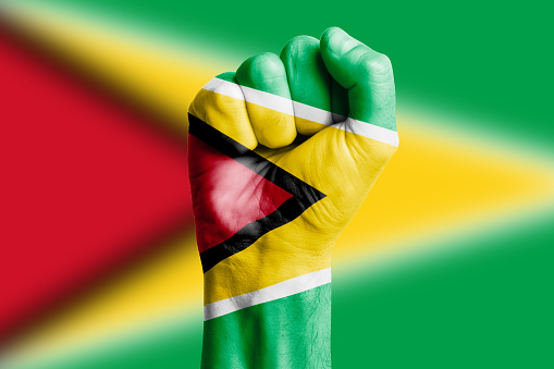 Man hand fist of GUYANA flag painted. Close-up
