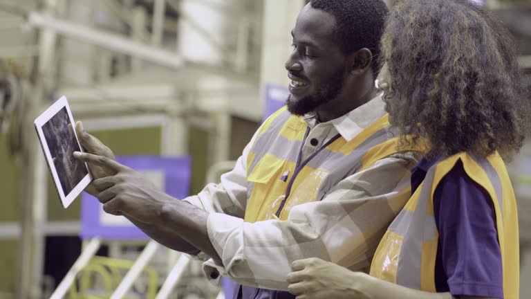 Blue collar worker use laptop to maintenance  ,working at a metalwork production factory . production engineers are examining the status of manufacturing.