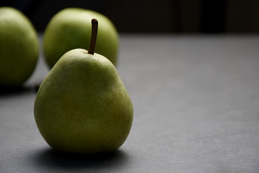 Fresh organic pear fruits on gray stone background with copy space