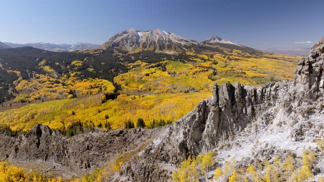 Aerial views of Colorado's Ragged and Marcelina mountain ranges during the vibrant colorful fall season. Shots capturing the majestic peaks and the vibrant color backdrop against the rugged peaks