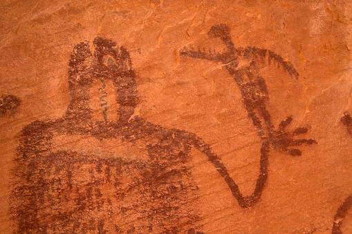 High on a cliff face, “snake man” Barrier Canyon style pictographs remain in sandstone cliffs on public lands just outside Canyonlands National Park in Moab, Utah.