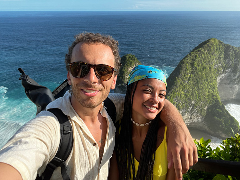Couple in love taking selfie at the Manta Bay or Kelingking Beach on Nusa Penida Island, Bali, Indonesia