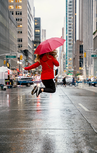 Woman posing with a red umbrella on 6th Avenue New York City