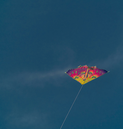 Color kite with blue sky and white clouds in sunny nice autumn windy evening