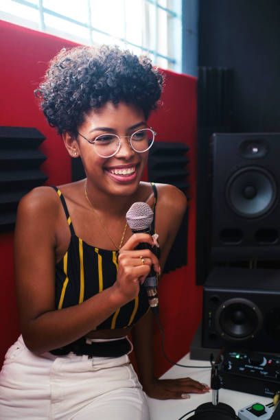 istock Smiling afro woman holding the microphone with one hand. 1745142305