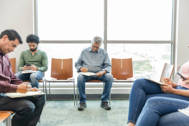 istock Diverse people fill out forms in doctor's waiting room 1745157917