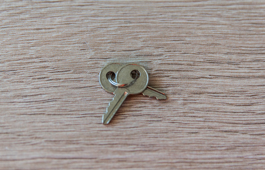 Two old iron keys on the wood table background. Copy space. Flat lay.