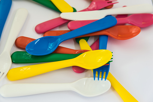 Multicolor plastic little spoons on the white background.