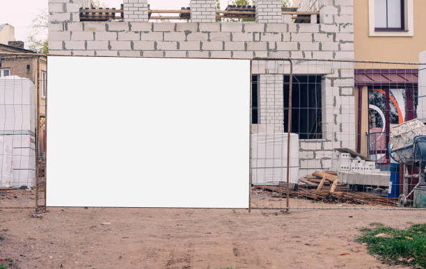 istock Empty white signboard mounted on steel fence at construction site 1745208193