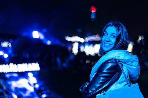 Portrait of a woman at a fair with a smiling face looking at camera at night.