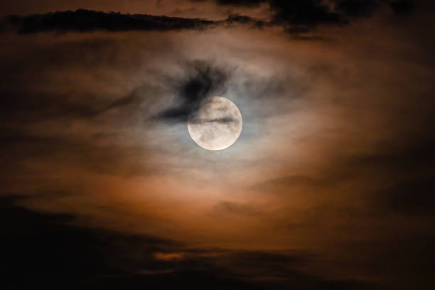 istock Full moon on a cloudy night. Natural colored clouds around the Moon 1745210376