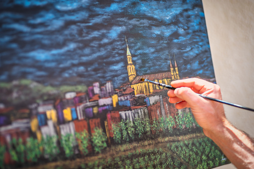 detail of and artist painter paiting a city on canvas