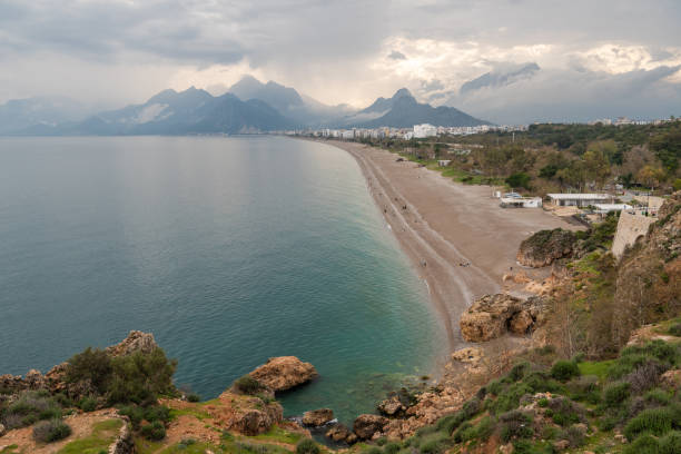 Konyaalti Beach in Antalya, Turkey. The beach is located on the western side of the city and stretches for 13 km primarily composed of fine pebbles, but also has some sand. The Beydaglar mountains can be seen in the background.