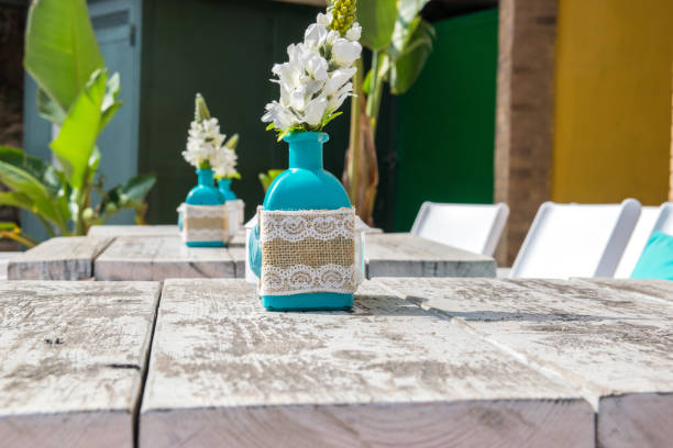 Warehouse on the open air. Chairs and tables outside on the summer sun weather. Vase with the flowers on the table for summer cafe.