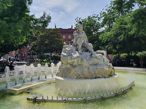 Toulouse, France - 18 May 2022 - The Goudouli fountain, Statue of P. Goudouli at Wilson's square