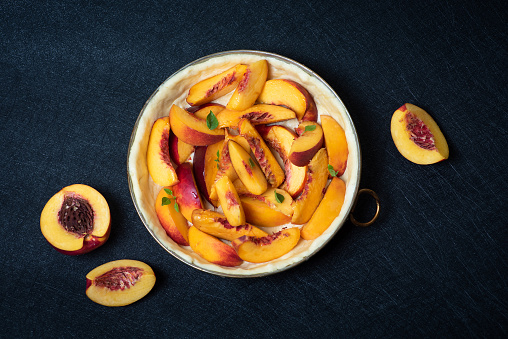 Homemade, unbaked tart with fresh peaches