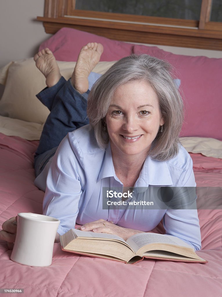 Donna rilassante con caffè e prenota - Foto stock royalty-free di 40-44 anni