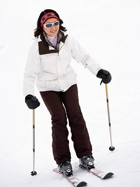 Happy female skier standing on a mountain during winter day. Copy space.