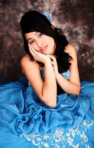 Close up shot of a hispanic teen wearing a prom or quinceanera gown.