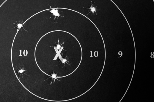 Paper target with bullet holes.
