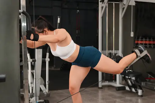 Female fitness influencer doing sit-ups in a white outdoor studio
