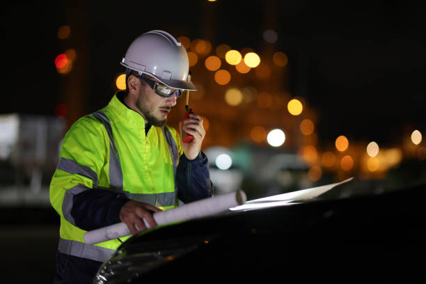 The Specialist electrical engineer communicated with the team via walkie-talkie at night against the  light of bokeh in the background