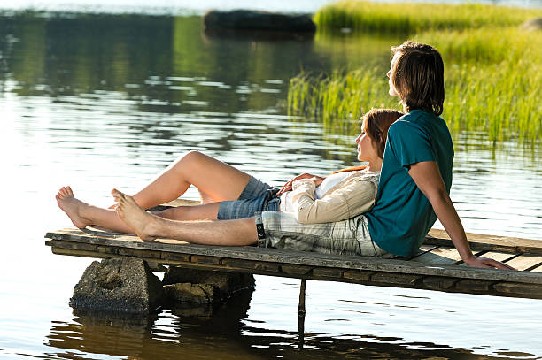 istock Caucasian couple lounging on pier sunset 174540659