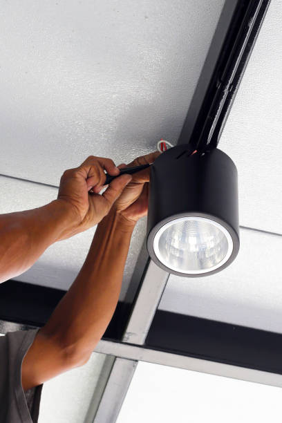 istock Hands of an electrician installing a light on the ceiling. 1745428687