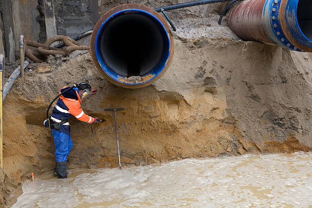 Sewerage pipe in the ground on a construction site ready to be concreted into position. The pipe is made of  brown PVC.