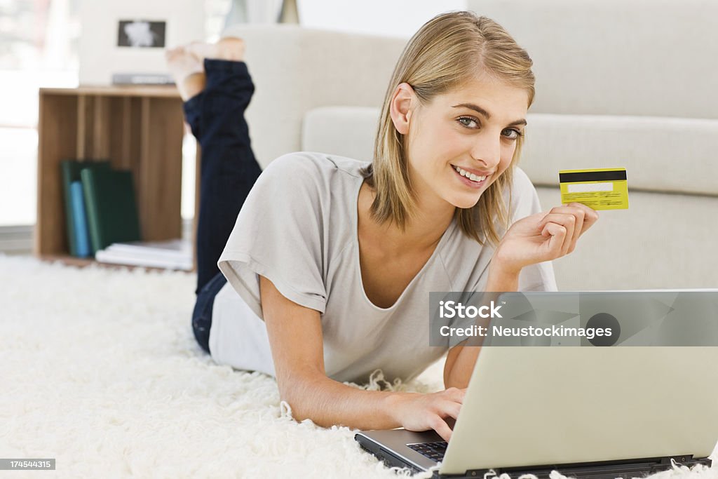 Młoda kobieta za pomocą laptopa posiadania karty kredytowej - Zbiór zdjęć royalty-free (Biały)