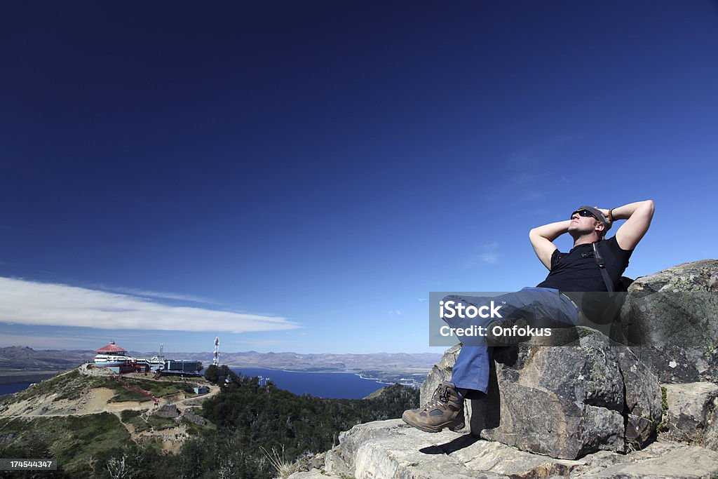 Hombre sentado y pensar en la Cumbre de la montaña - Foto de stock de 25-29 años libre de derechos