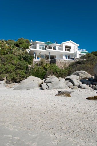 White beach house against a blue sky.Related images;