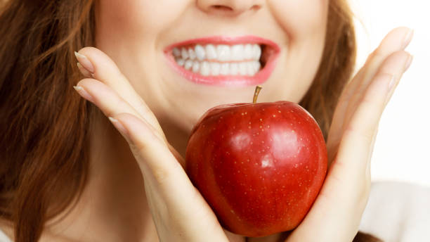 istock Woman holds apple fruit close to face 1745451747