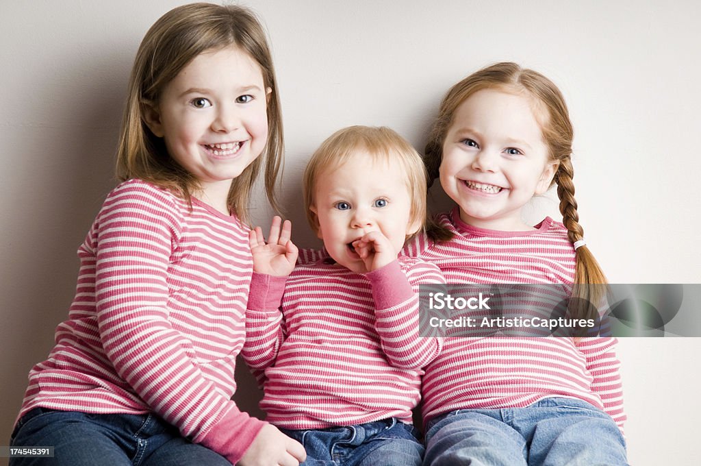 Три счастливый, соответствующее Сестры сидеть вместе и улыбается - Стоковые фото 12-17 месяцев роялти-фри