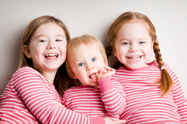 istock Three Matching Sisters Cuddling and Laughing Together 174545393