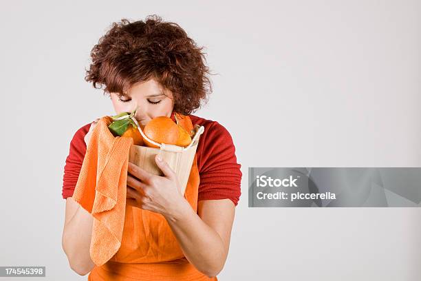 Cute Girl Smelling Oranges Stock Photo - Download Image Now - Adult, Apron, Basket