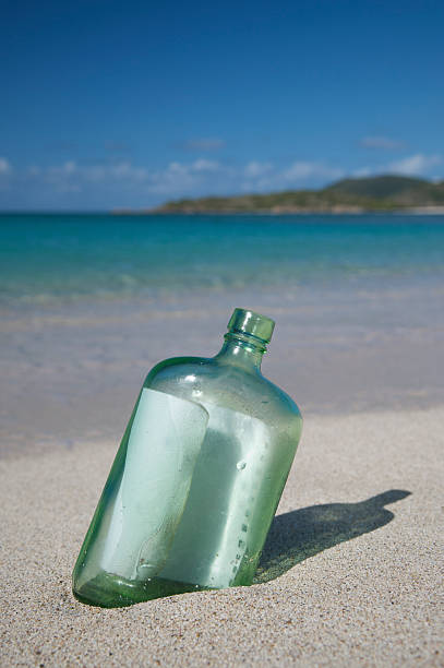 послание в бутылке вертикальные - message in a bottle beached bottle desert island стоковые фото и изображения