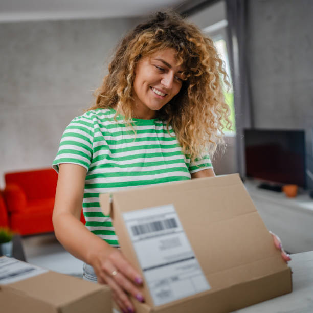 istock one happy woman open mail cardboard package box present at home 1745477253