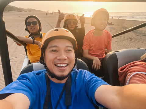 POV of Family Vacation Riding Offroad Vehicle at The Beach in Sunset Time